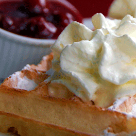 Waffles from Brussels with whipped cream and hot cherries